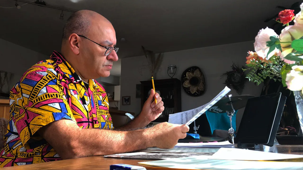 gio rossi compositore e arrangiatore mentre osserva una partitura musicale